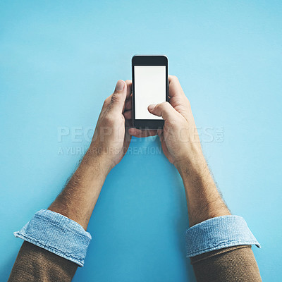 Buy stock photo Phone screen, mockup and hands of man in studio with social media, streaming or subscription on blue background. Smartphone, space and person with app for online, competition or gaming sign up promo