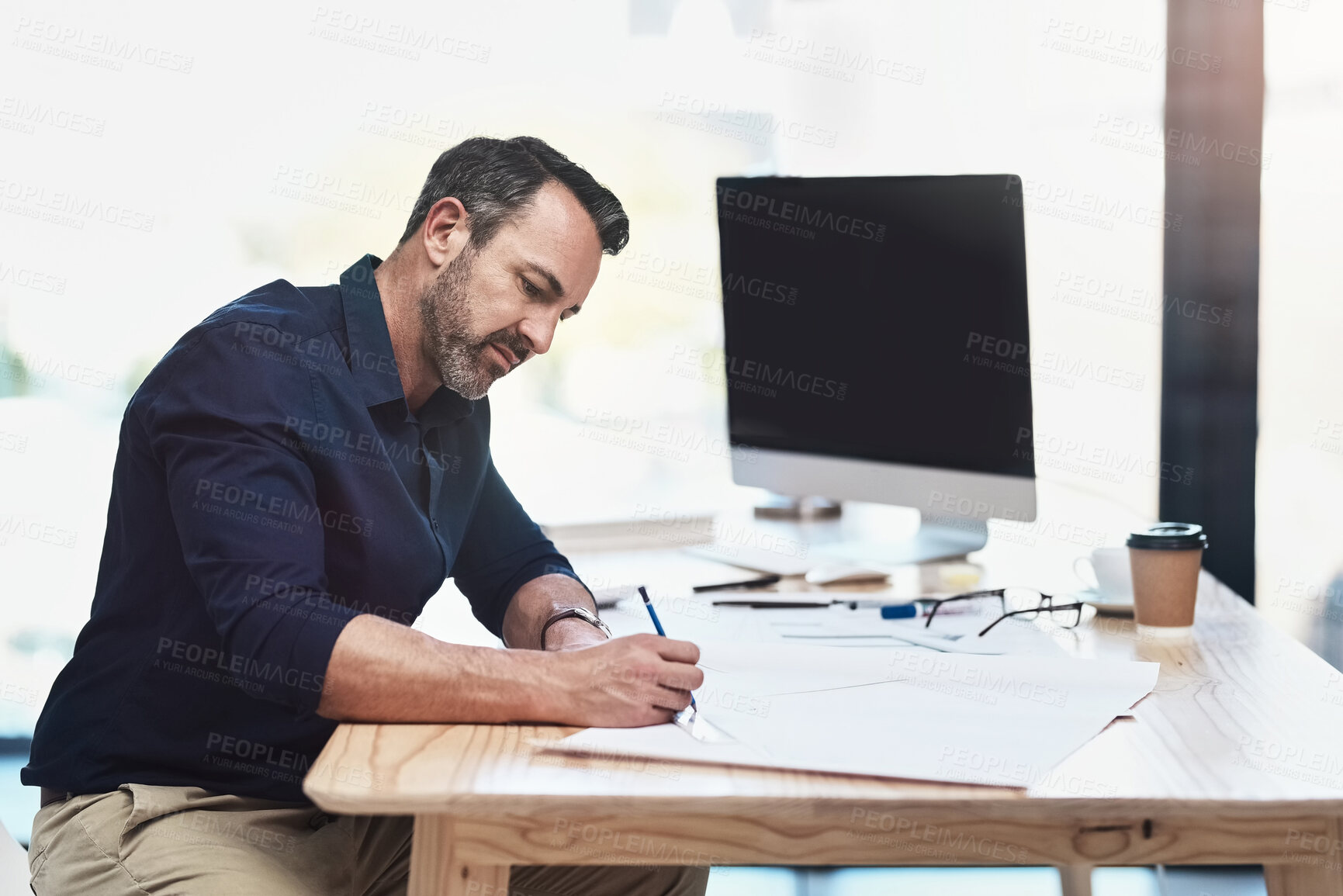 Buy stock photo Shot of a mature male architect working in his office