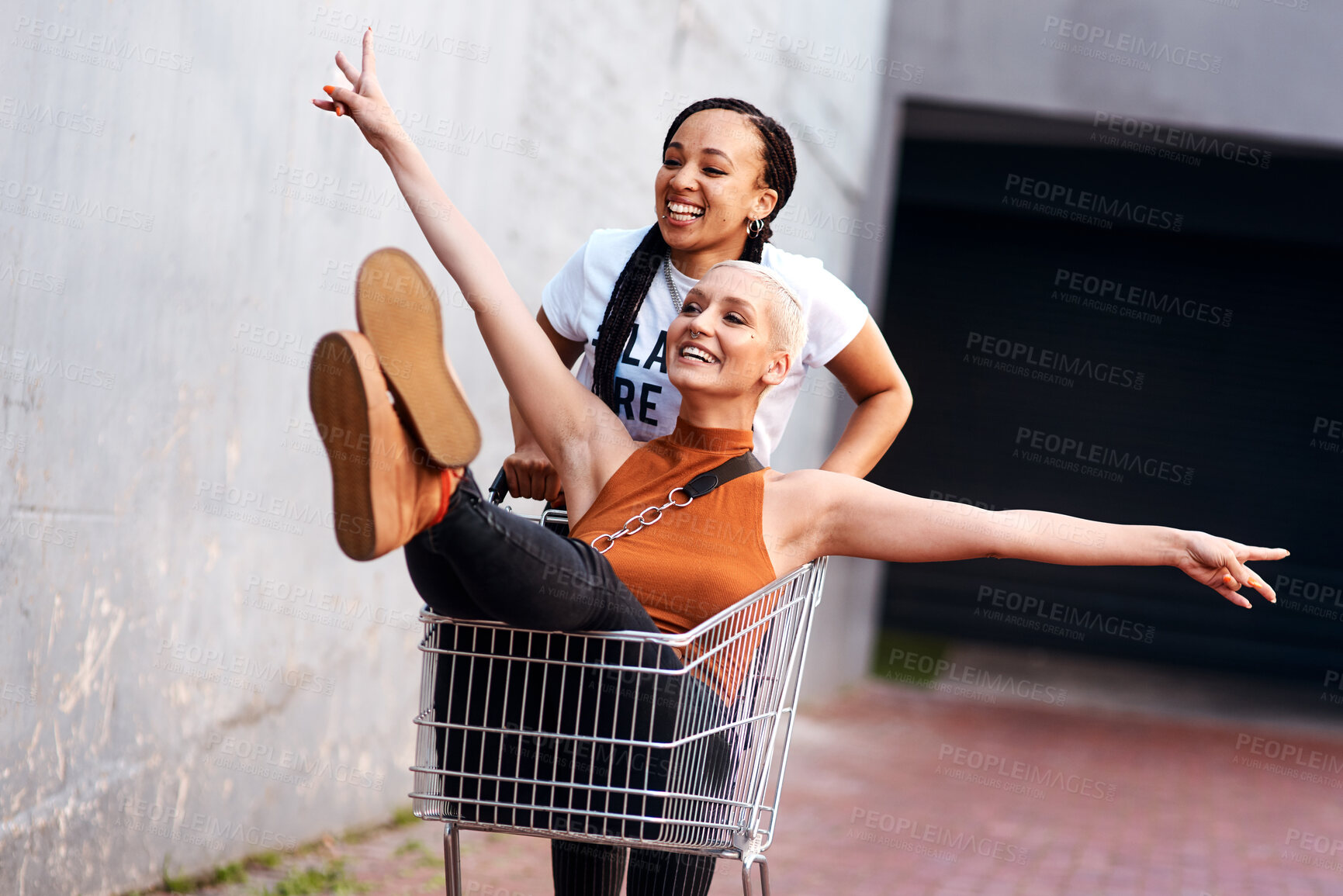 Buy stock photo Friends, happy and shopping cart in outdoor for play, funny and bonding together in city for freedom. Women, town and adventure in trolley for comedy, laughing and crazy happiness in urban on weekend