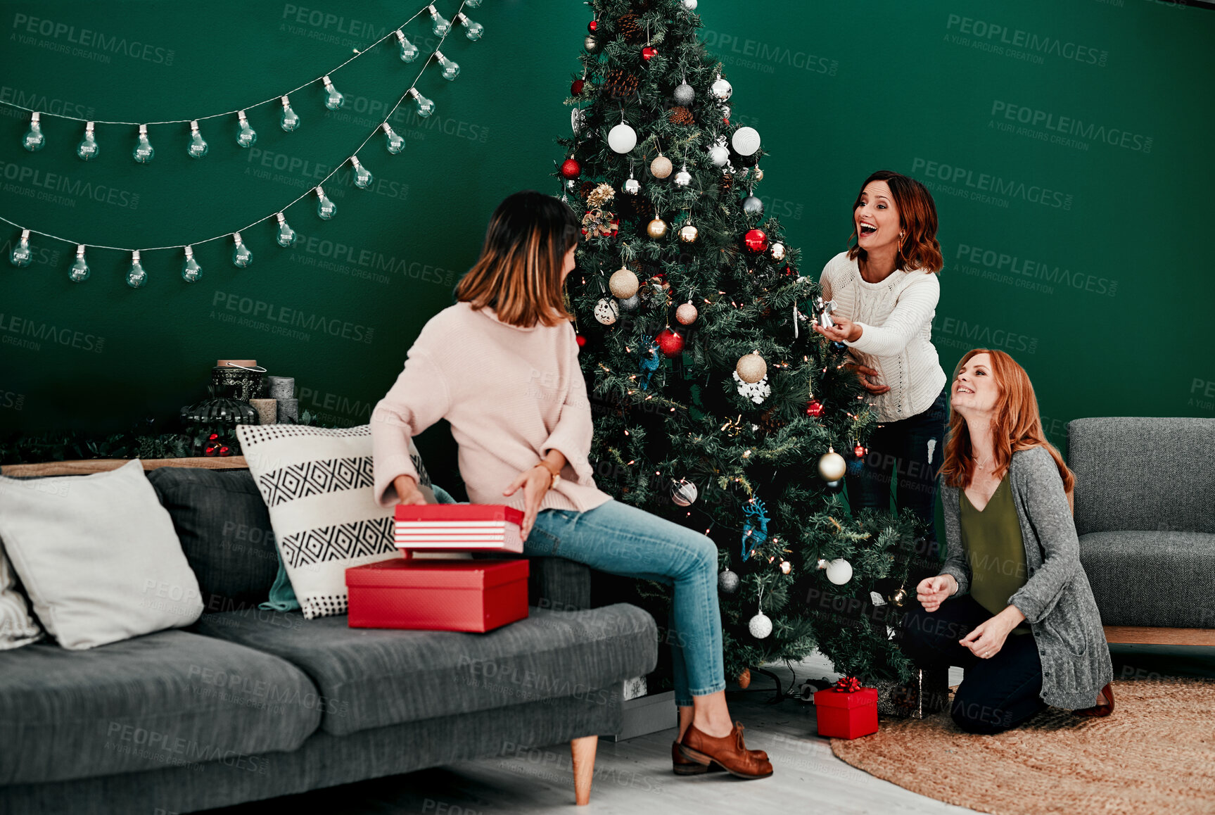 Buy stock photo Christmas tree, gift and women in living room for interior, excited and season happiness in lounge. Xmas ornaments, holiday and friends by couch for bonding, celebration and tradition in winter