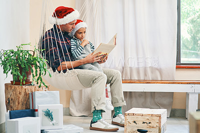 Buy stock photo Father, son and reading with book on christmas day at home for story, novel or december holiday. Dad bonding with young child, kid or little boy for fairytale, chapter or childhood on festive weekend