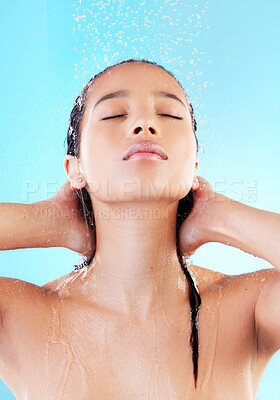 Buy stock photo Woman, washing hair or showering in blue studio background for cosmetics, hygiene and wellness. Female person, eyes closed and water cleaning head for grooming, skincare and treatment or bath