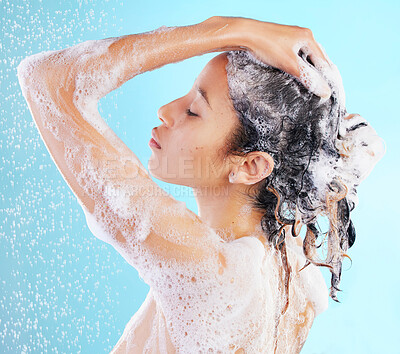 Buy stock photo Wash, hair care and woman shower in studio for hygiene, shampoo or skincare on blue background. Back, wellness and model body with water splash for morning routine, cleaning foam or dermatology