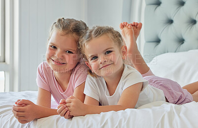 Buy stock photo Sisters, kids and portrait to smile in bedroom, morning and wake up together in home. Girls, children and weekend for lying on bed or bonding for relationship, support and peace in security or relax