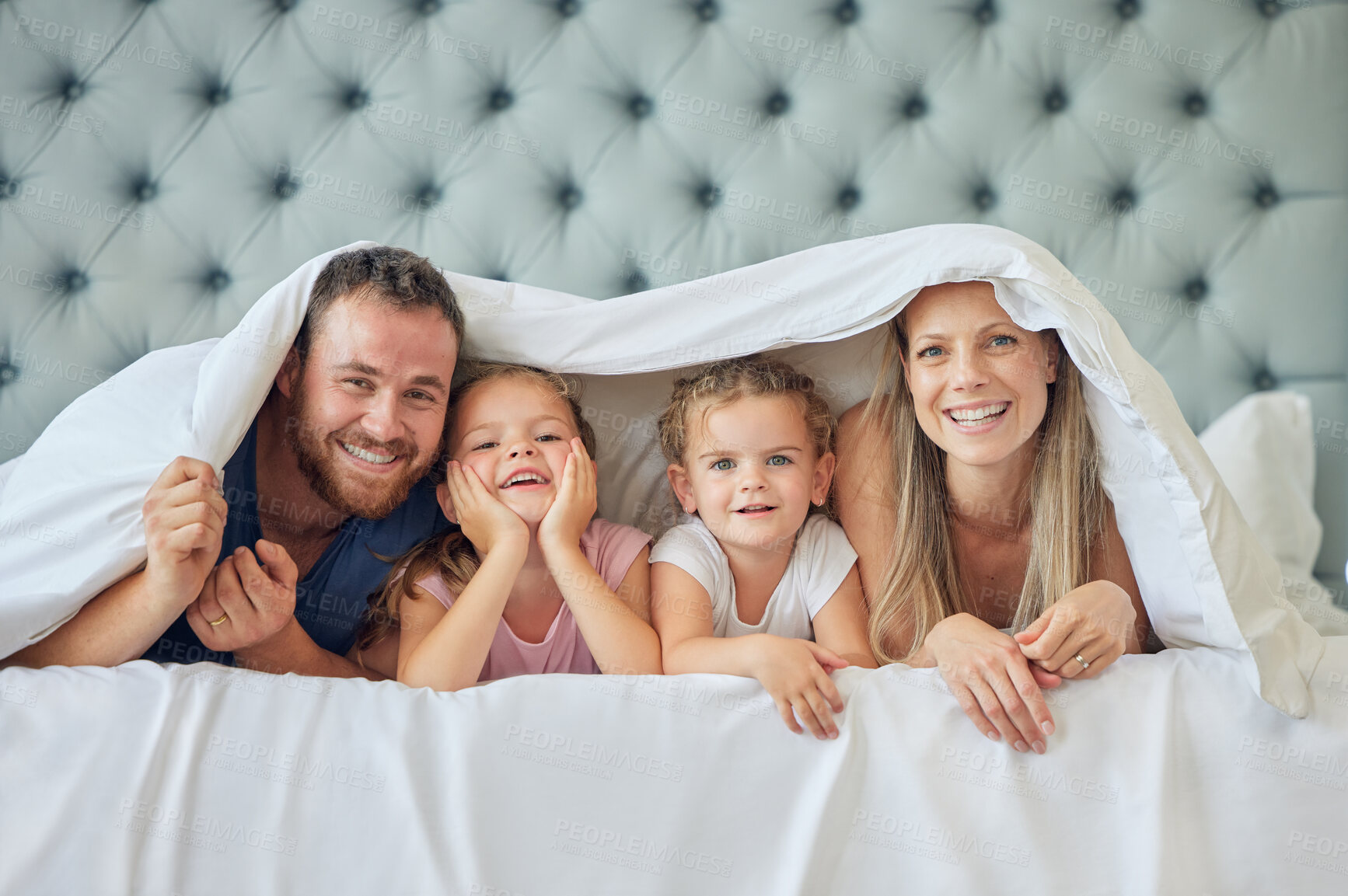 Buy stock photo Family, portrait and happy in bedroom on weekend with relax, comfort or safety in bonding or together. People, parents and children with rest, blanket in morning in home for love, affection or peace
