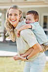 Happy single mother giving her little son a piggyback ride outside in a garden. Smiling caucasian single parent bonding with her adorable child in the backyard. Playful kid enjoying free time with mom