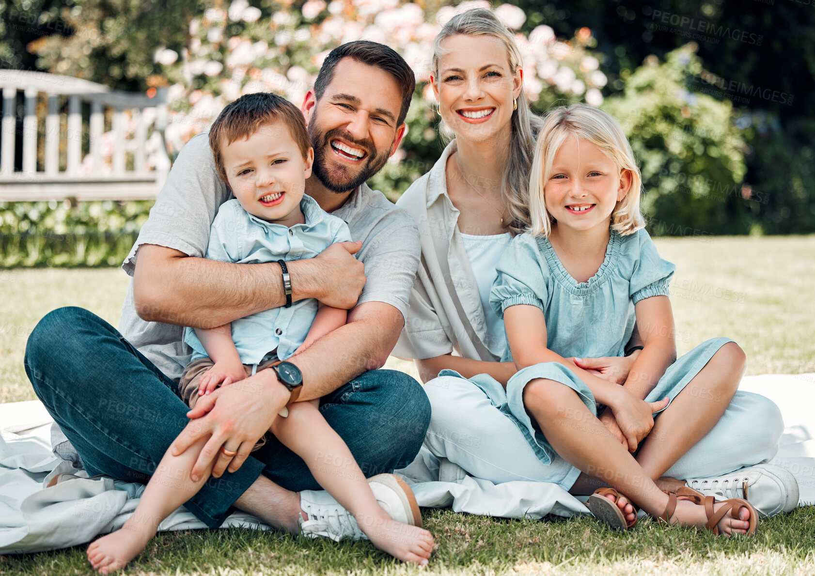 Buy stock photo Portrait, family and grass for picnic, hug and outdoor to relax in summer, love and bonding in break. Parents, woman and man with children, happy and weekend for connecting with young kids in park