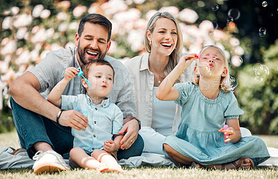 Buy stock photo Happy, family and blowing bubbles in garden at home with fun, bonding and support with care. Parents, kids and smile or laugh for child development or growth in outdoor with love and security