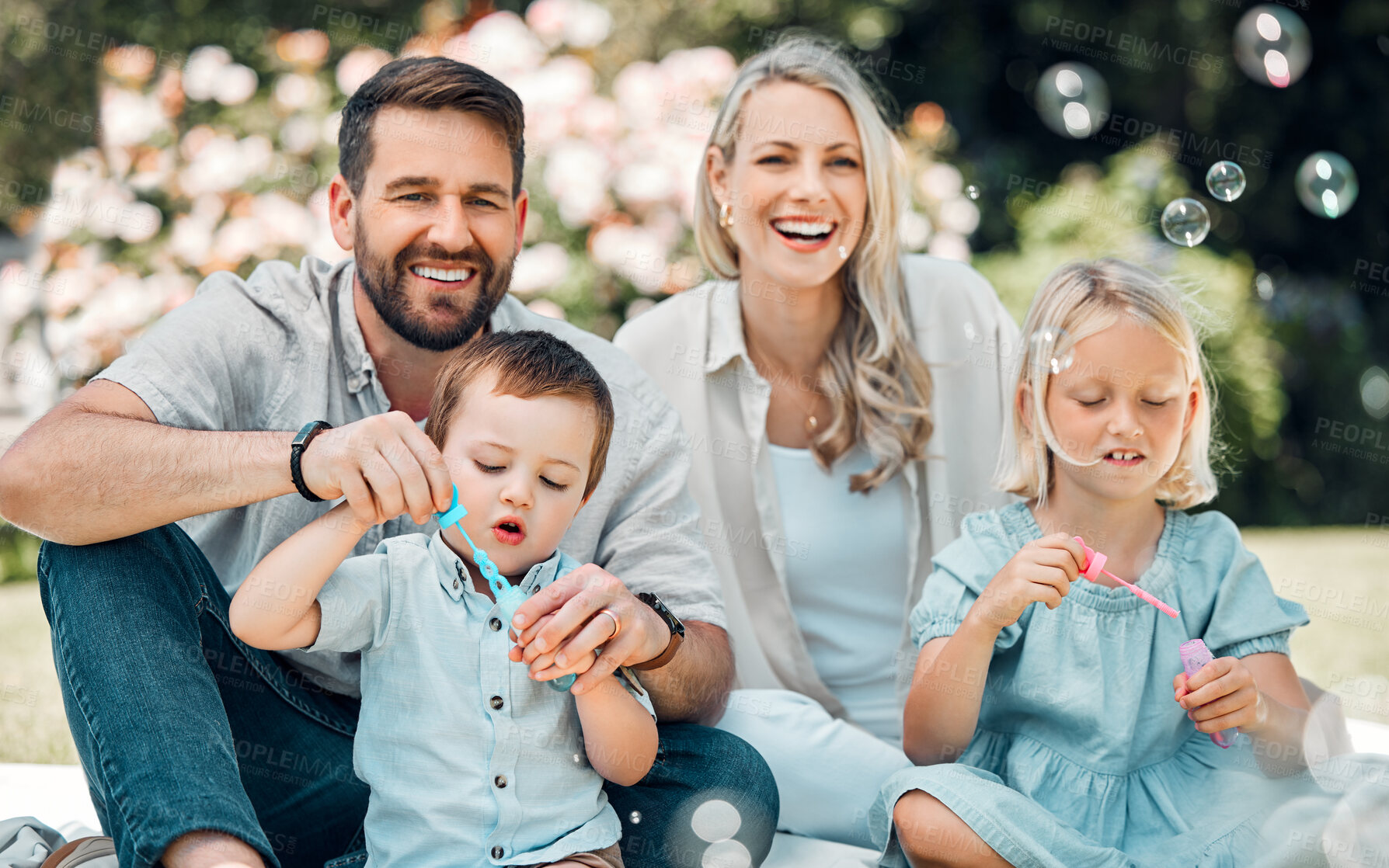 Buy stock photo Smile, family and blowing bubbles in garden at home with fun, bonding and support with care. Parents, kids and happy on portrait for child development or growth in outdoor with love and learning