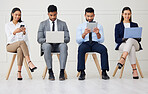 Group of diverse businesspeople waiting for interview and using technology. Team of young applicants sitting together. Professional candidates in line for job opening, vacancy and office opportunity