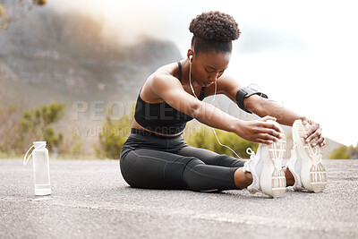 Buy stock photo Fitness, black woman or stretching legs in road for running, workout or training at sunset with music or water. Exercise, wellness or runner streaming podcast with body warm up for sports performance