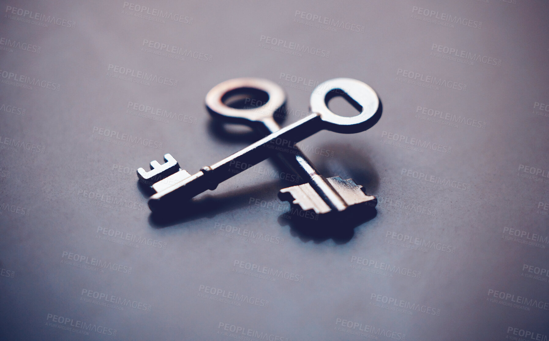 Buy stock photo Keys, security and investment with metal on gray background, new home and opportunity for real estate in studio. Unlock, future and entry tool or potential growth, space and property or house access
