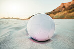 Beach, ball and volleyball on sand, a game at sunset at tropical ocean destination. Fitness, fun and summer sports at the sea in the evening. White sandy coast, a volley ball and an empty seascape.