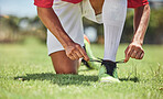 Hands, shoes and soccer player at a soccer field, tie lace and prepare for training, sports and fitness game. Football, hand and football player getting ready for workout, exercise and sport practice