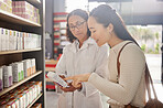 Asian woman, medicine shopping or pharmacist in pharmacy reading retail healthcare information together. Trust. women or doctor helping a customer with store medication advice, pills or medical drugs