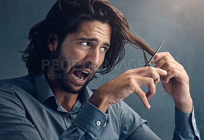 Buy stock photo Trim, hair humor and man with scissors for grooming, facial cleaning and funny joke on grey studio background. Barber, mistake and face of scared model trimming fear for comedy cosmetic fail look