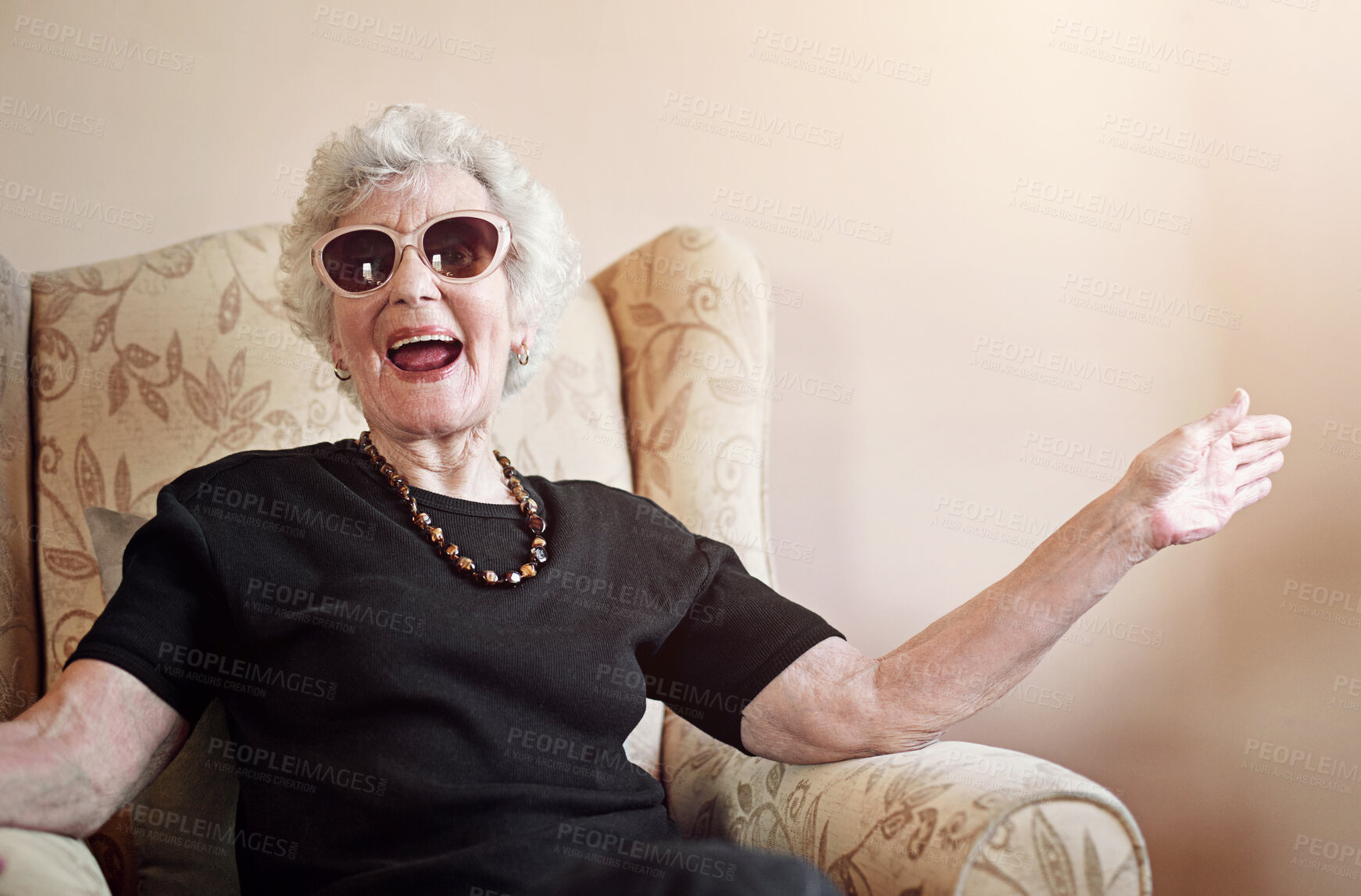 Buy stock photo Senior, woman and happy with sunglasses in home on sofa with fun retirement, laughing and relax in living room. Elderly, person and excited with eyewear on couch in hospice with wellness and funny