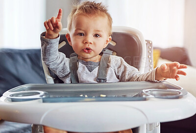 Buy stock photo Baby, high chair and home in portrait for learning or wellness, motor skills with finger for growth. Young, boy child and hand in house for healthy development, waiting for meal time in apartment