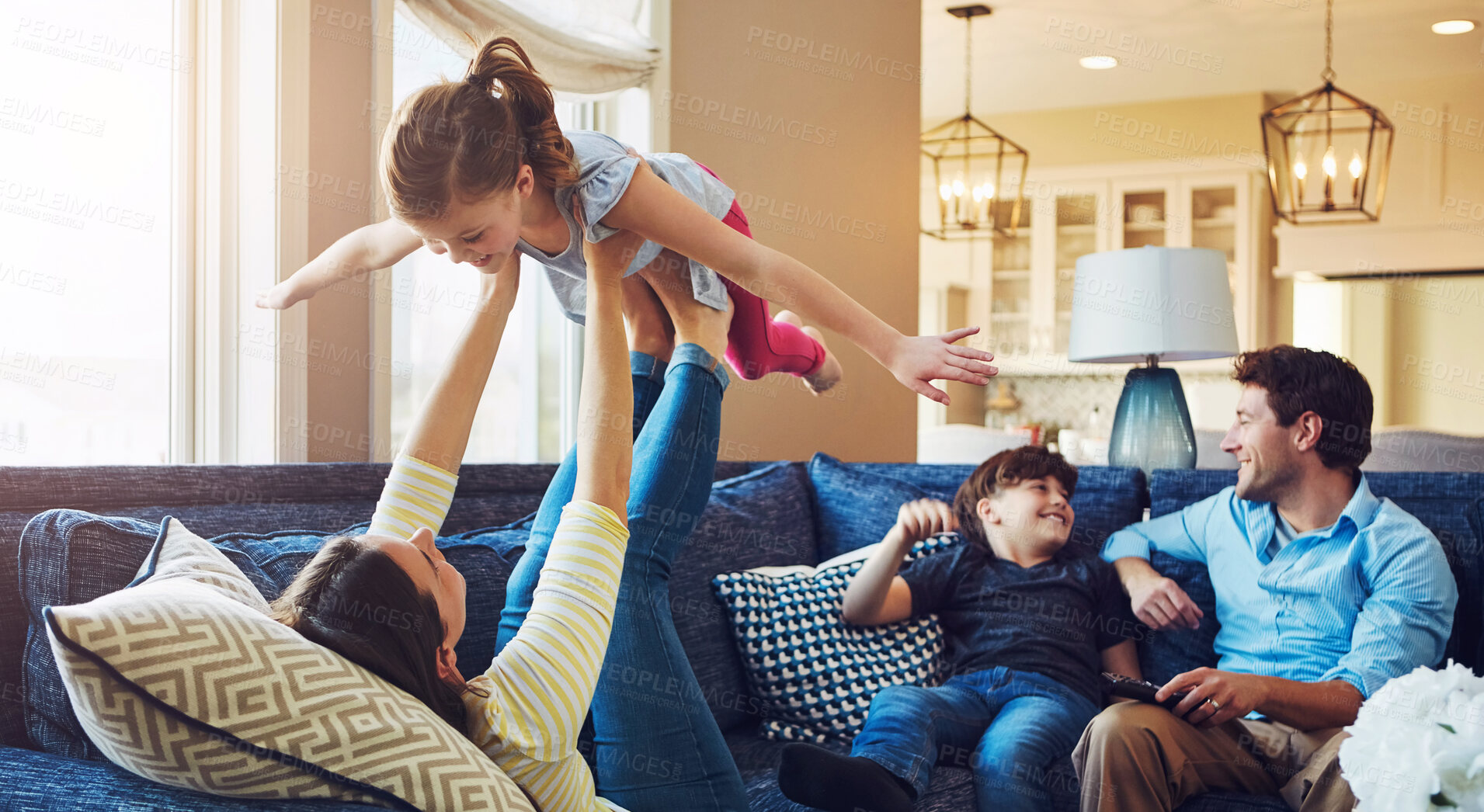 Buy stock photo Airplane, playing and family on sofa in home relaxing with care, happiness and love together. Smile, bonding and girl child with flying role play with mom, brother and dad sitting on couch in house.