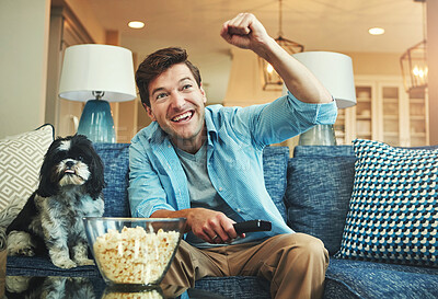 Buy stock photo Celebrate, dog and man with popcorn on sofa watching sports match on television at home. Happy, winning and male person relaxing and streaming football game in living room with pet puppy at apartment