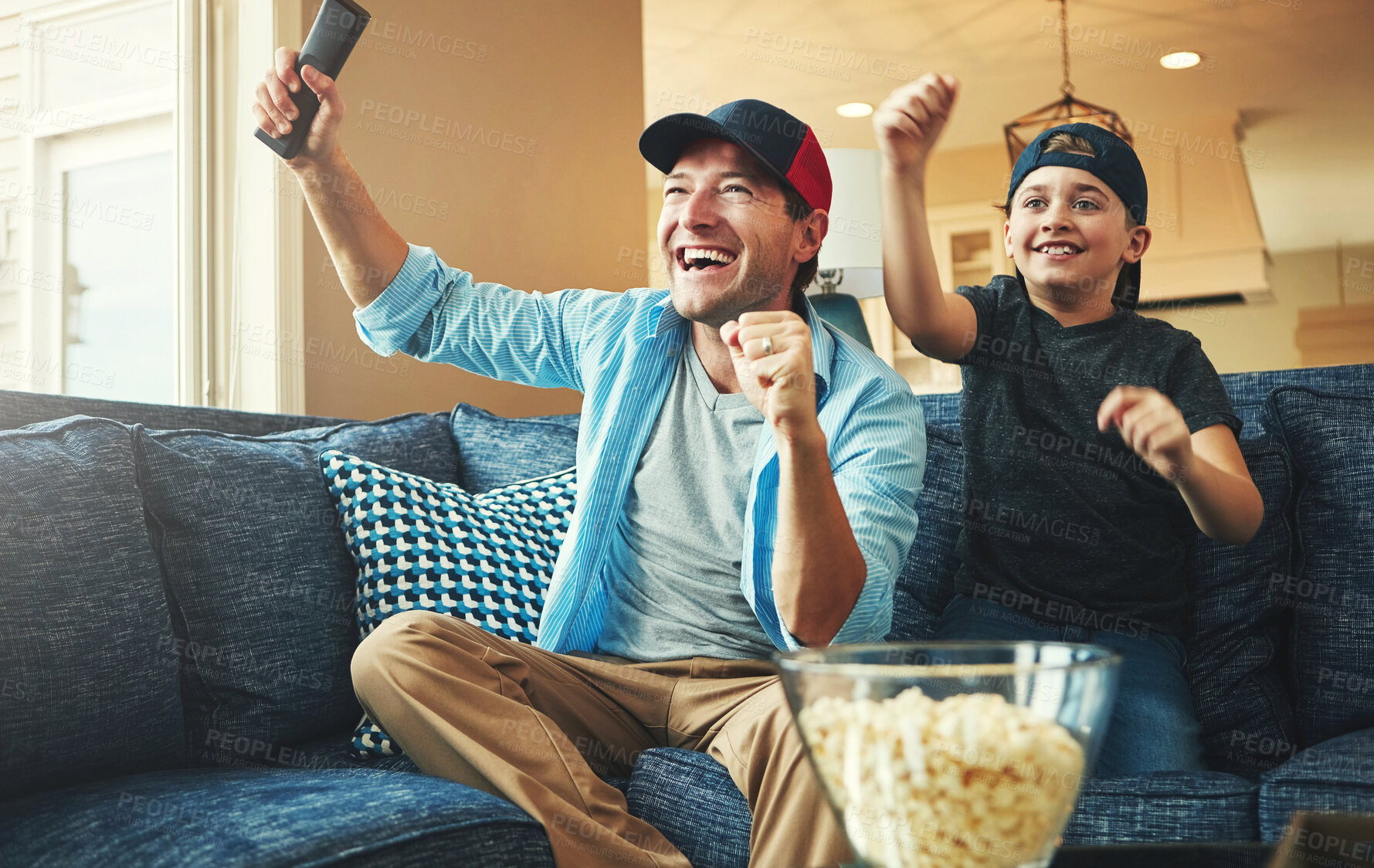 Buy stock photo Television, kid and man with celebration on sofa for streaming, subscription and watching together. Son, dad and popcorn with tv remote in fist for bonding, success and live broadcast of sports match