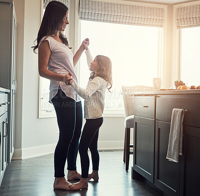 Buy stock photo Love, dance or mother and daughter in a kitchen for fun, learning and holding hands with trust, care or gratitude at home. Balance, feet and woman with child in a house for bonding with radio music