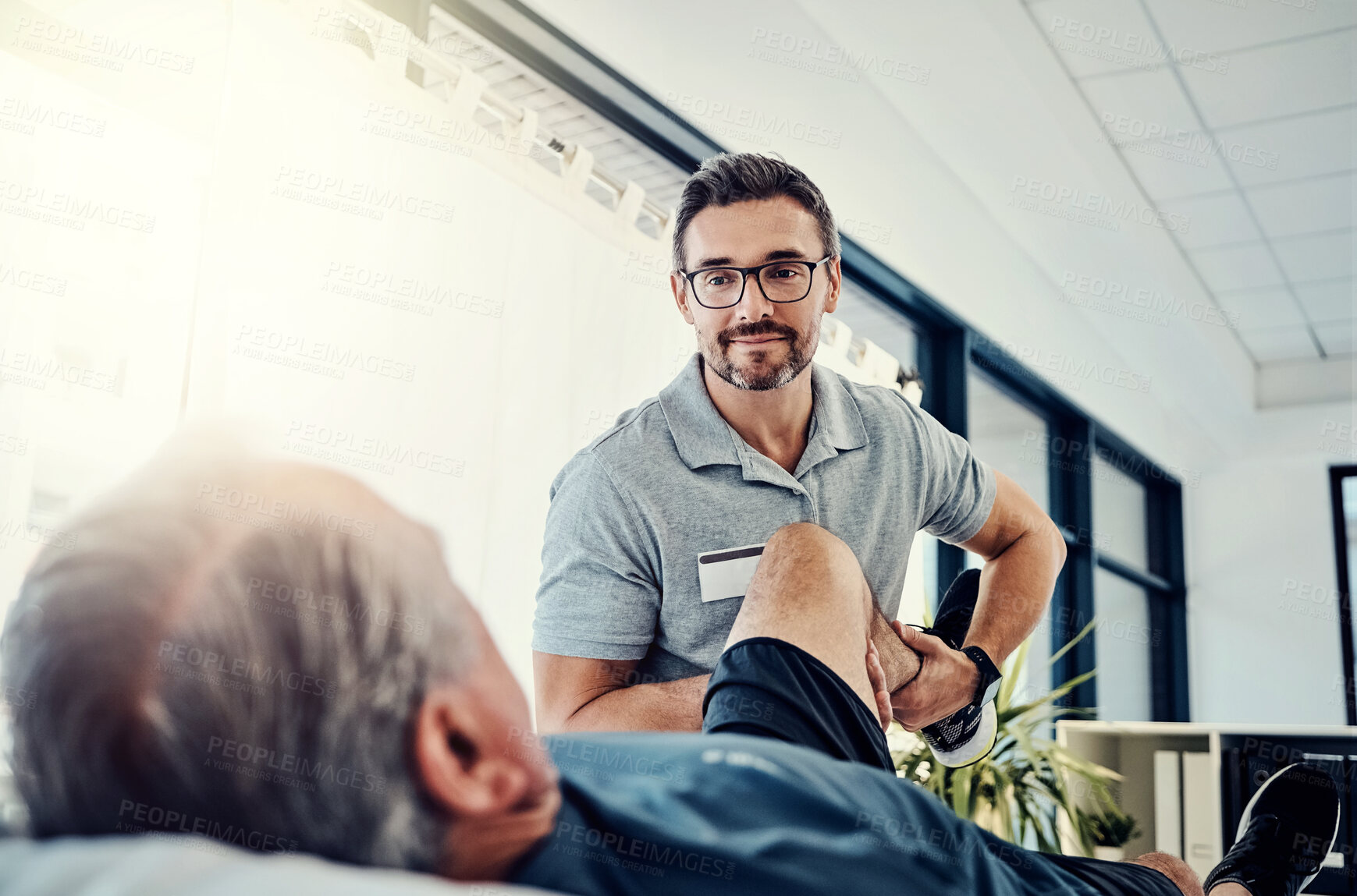 Buy stock photo Physiotherapist, senior man and stretching leg for knee pain, medical and consultant with fitness injury. Consultation, chiropractor and physical therapy with rehabilitation and care in doctor office