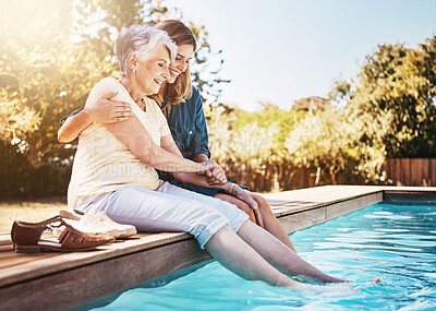 Buy stock photo Mother, daughter and happiness by pool for bonding, hug or relax with lens flare in garden. Senior mom, woman and outdoor with smile for wellness, family with embrace or love and feet in water