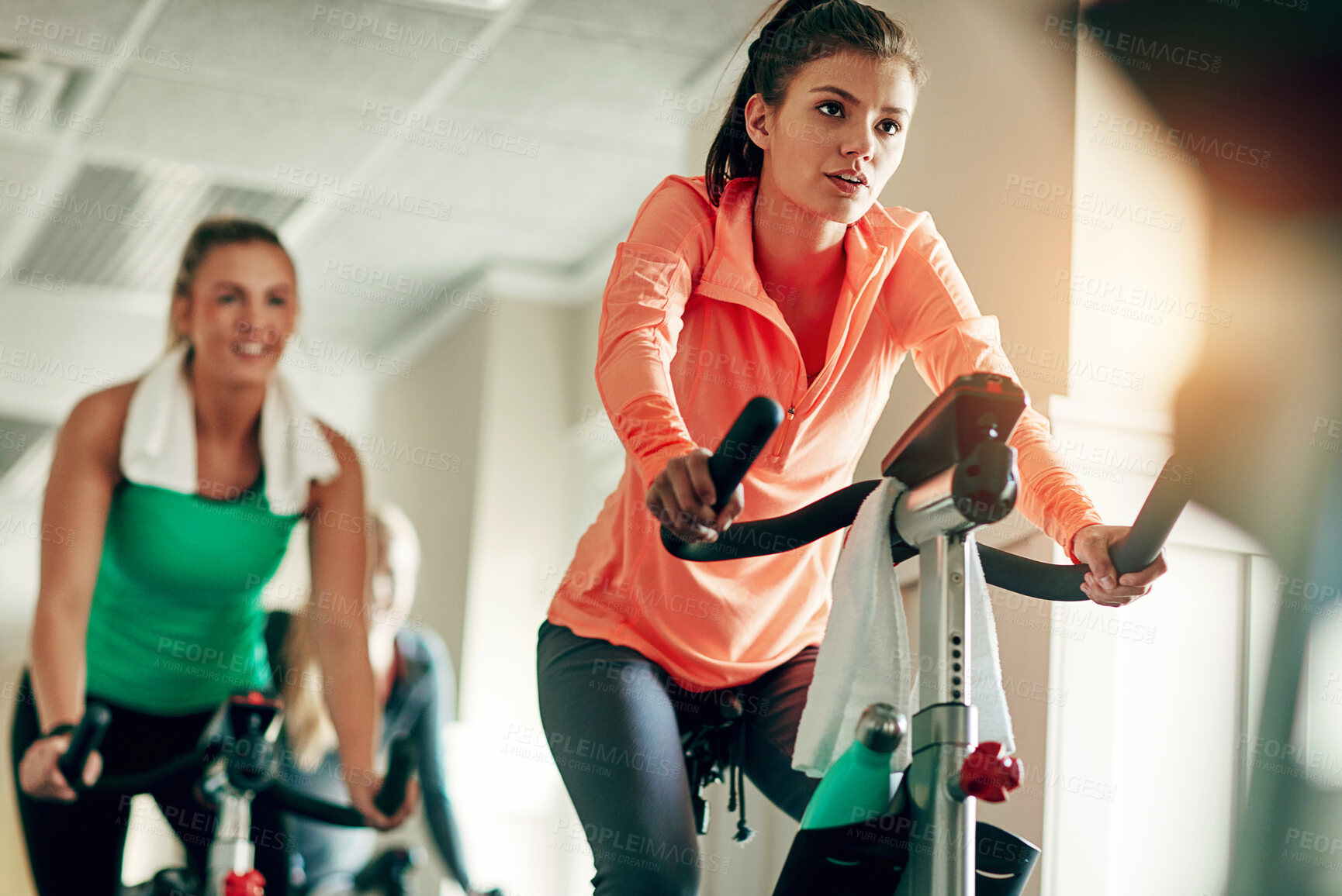 Buy stock photo Woman, cycling and workout with spin class at gym for cardio exercise or indoor training together. Active female person or group of cyclists riding on equipment or bicycle for fitness at health club