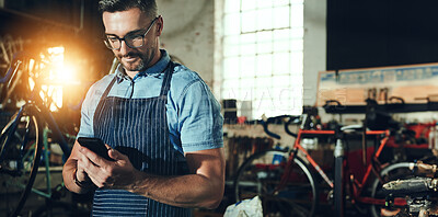Buy stock photo Bicycle, man and phone for shop, garage and small business of mechanic, engineer or entrepreneur. Proud, owner or person with service maintenance for bike, inspection or transport with mobile app