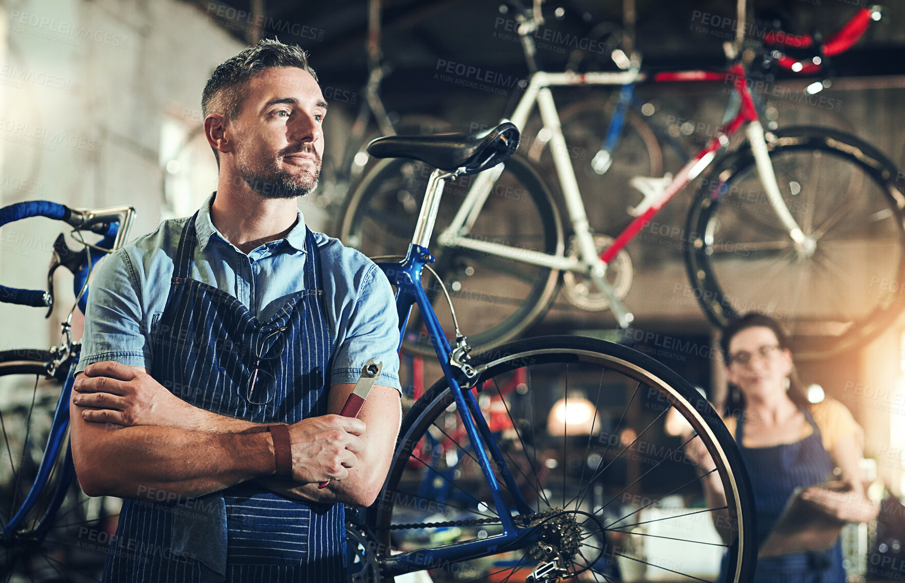 Buy stock photo Bicycle, garage and repair shop for man, thinking and small business of mechanic, apron and equipment. Proud, owner and people with service, maintenance and tools for bike, technician and working