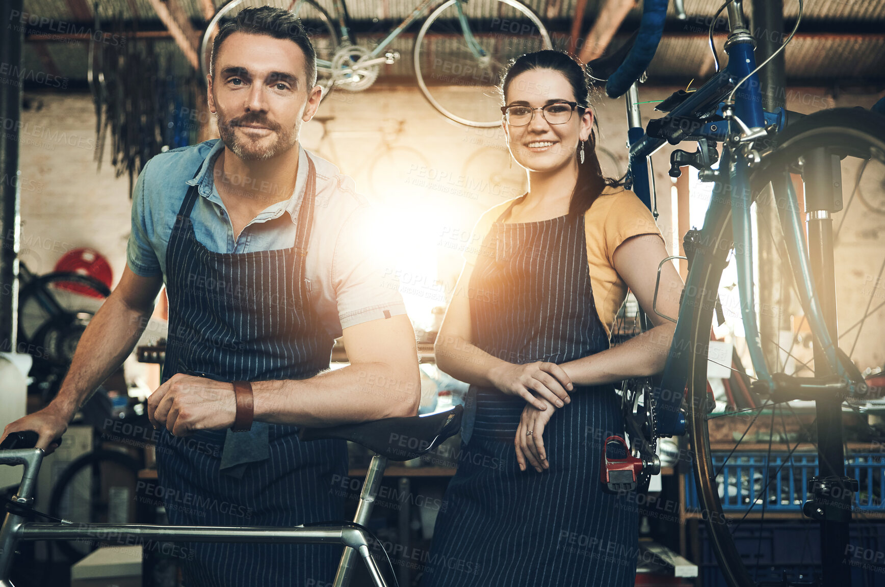 Buy stock photo Portrait, employee and bicycle repair shop with smile from mechanic, technician and maintenance work. Workshop, service and happy business owner with staff and bike for fixing with apron and pride