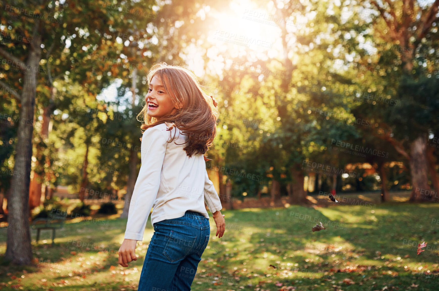 Buy stock photo Girl, child and playing in park with leaves for adventure, fun activity or spinning with enjoyment in summer. Kid, happy and excited with freedom, holiday or wellness on grass in nature with sunlight