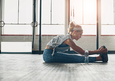 Buy stock photo Exercise, legs and warm up with woman on floor of gym for health, improvement or wellness. Fitness, stretching or training and athlete getting ready for physical workout routine with music streaming