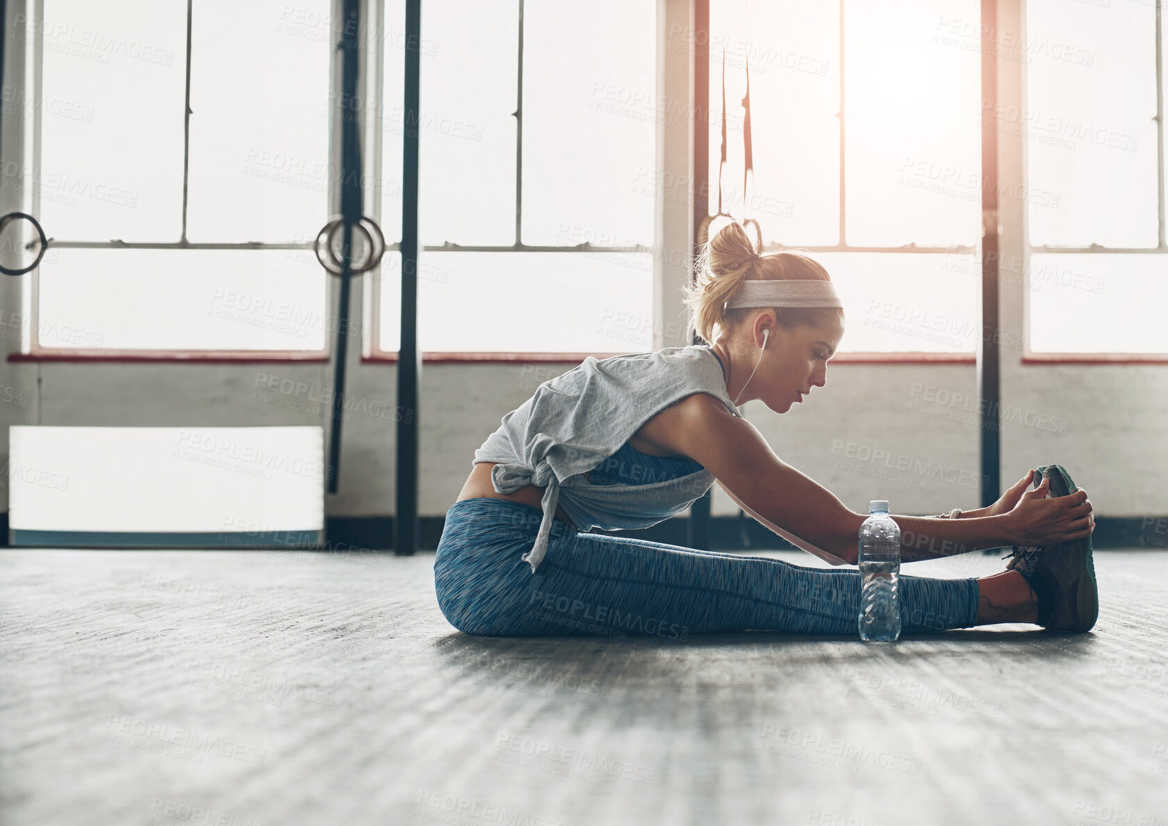 Buy stock photo Exercise, legs and warm up with woman on floor of gym for health, improvement or wellness. Fitness, stretching or training and athlete getting ready for physical workout routine with music streaming