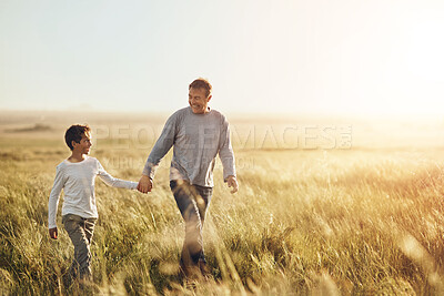 Buy stock photo Holding hands, walking and father with child in nature at sunset for bonding together on vacation. Happy, farm and dad with boy kid on adventure, holiday or weekend trip in agriculture countryside.