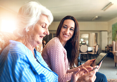 Buy stock photo Senior woman, daughter and tablet on sofa for streaming, internet and video call in home living room. Elderly person, child and smile on couch with helping hand for tech savvy, app or communication