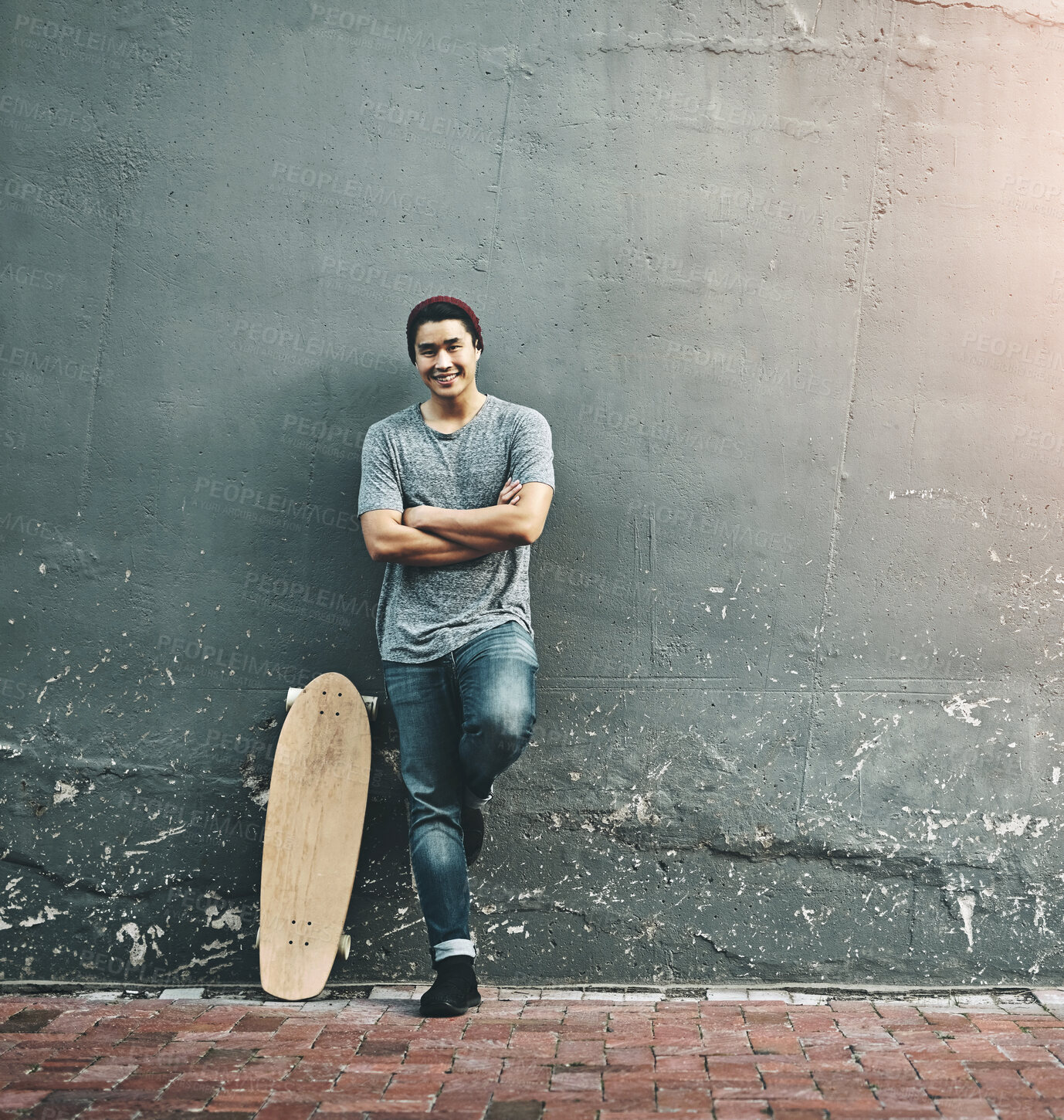 Buy stock photo Fashion, skateboard and portrait of man in city with trendy style, cool outfit and crossed arms outdoors. Happy, confidence and person on wall background for skateboarding, weekend fun and holiday