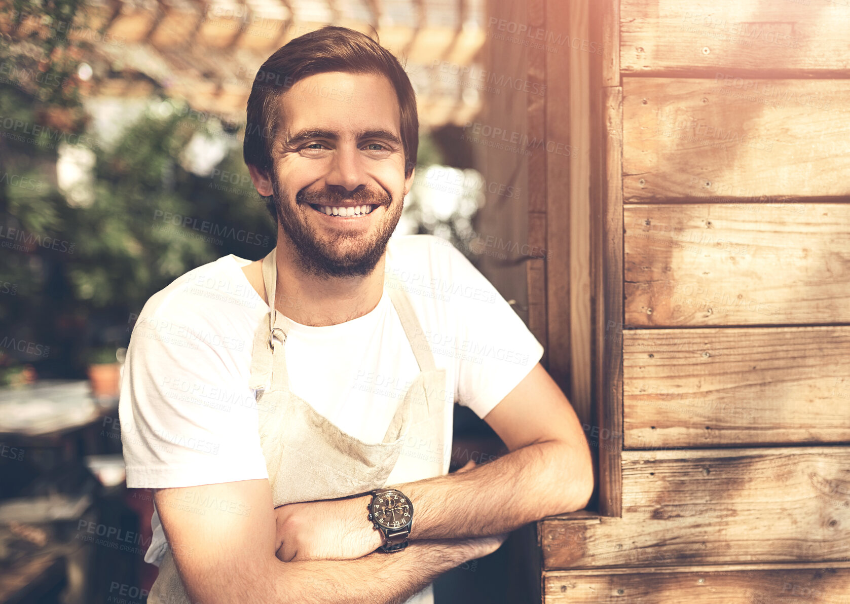 Buy stock photo Smile, portrait and man waiter outdoor with crossed arms for positive, confidence and career. Happy, pride and male barista or hospitality worker with apron from Canada by wooden cafe for welcome.
