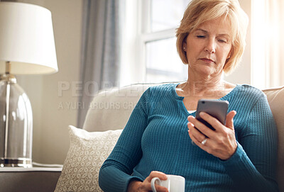 Buy stock photo Home, serious and old woman on sofa with smartphone, typing and connection with social media in living room. Senior person, coffee and apartment with cellphone, internet and digital app with message