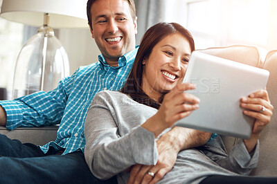 Buy stock photo Tablet, couple and social media on sofa for online post, scroll internet or relax in living room. Lens flare, digital and happy woman with man for entertainment, meme or watching comedy movie in home