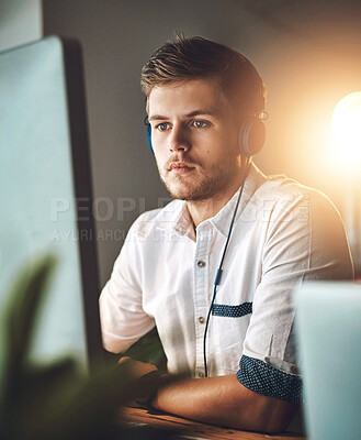 Buy stock photo Computer, music and web design with business man at desk in office for creative development. Concentration, headphones and streaming audio with serious employee in workplace for radio or research