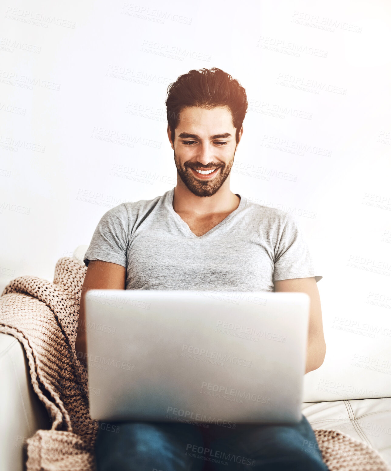 Buy stock photo Remote work, happy man and laptop on sofa for typing, communication and review at home. Male freelancer, technology and contact on couch for research, positive response and blog writing in lounge