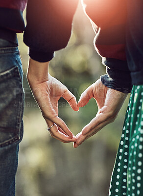 Buy stock photo Couple, hands and heart for love in outdoor with partnership, commitment and support of romance wellness. People, peace and connection with icon trust, hope and teamwork together in nature vacation