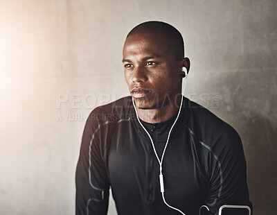 Buy stock photo Thinking, exercise or fitness man with earphones on wall background for wellness, marathon and training with mockup. Sports, space or African runner streaming music, podcast or radio for workout