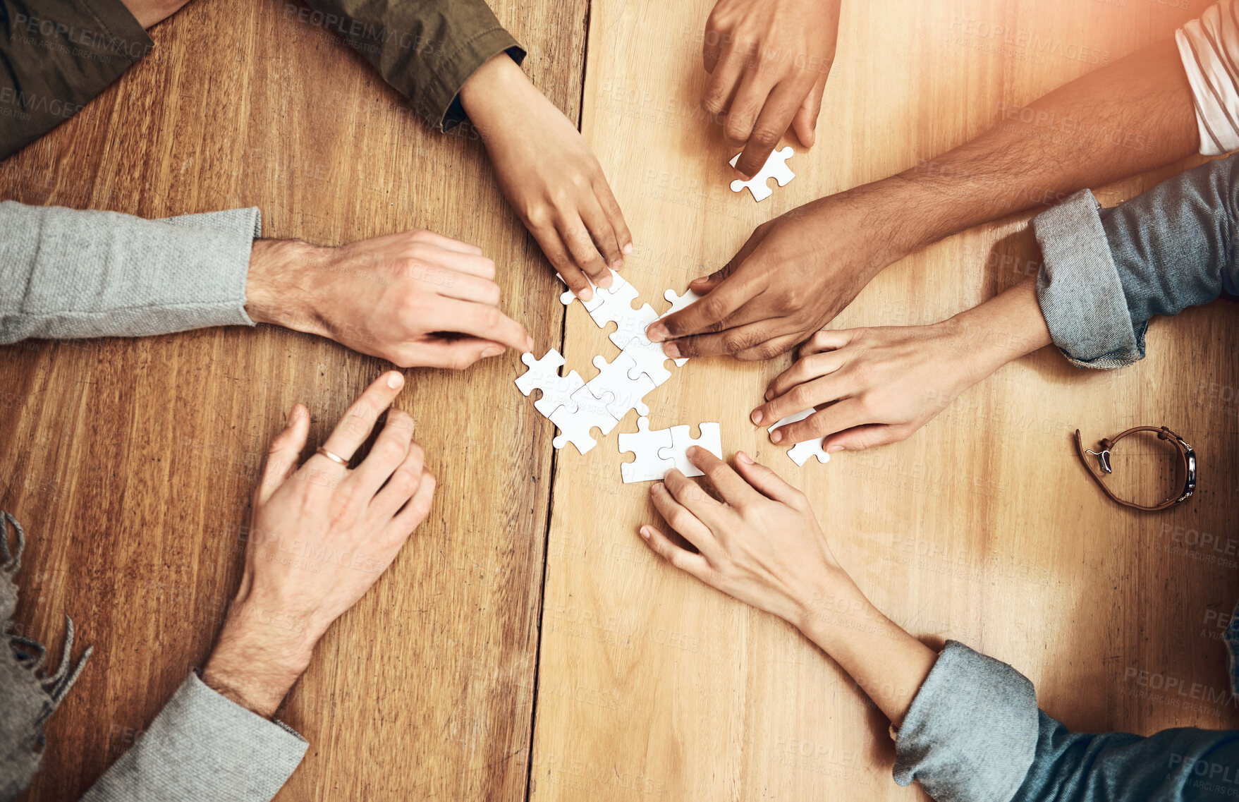 Buy stock photo Puzzle, above and hands of business people for teamwork, collaboration and working together. Meeting, diversity and workers with jigsaw for problem solving, challenge and cooperation in office