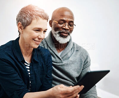 Buy stock photo Senior, couple and tablet in home together,  living room and browsing internet news or connection in apartment. Online, website and weekend or tech with interracial people, relationship and lounge