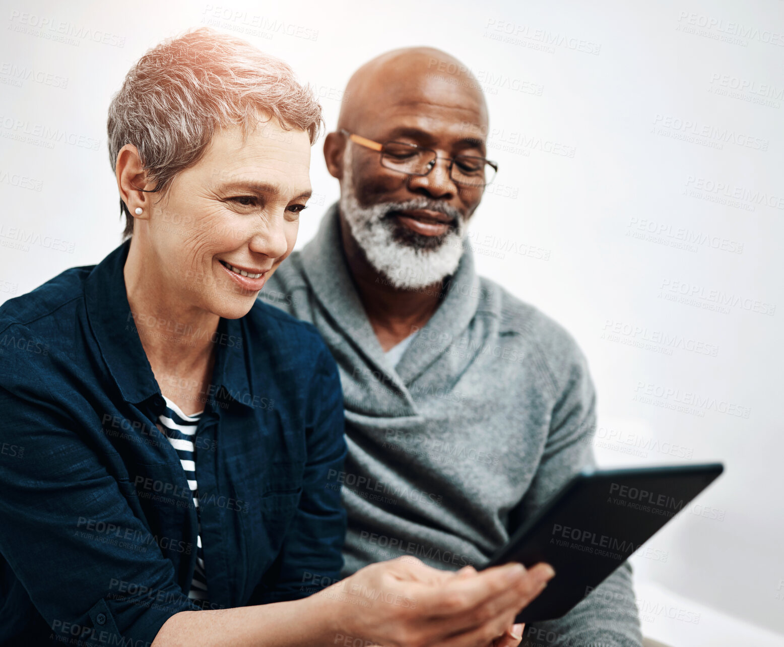 Buy stock photo Senior, couple and tablet in home together,  living room and browsing internet news or connection in apartment. Online, website and weekend or tech with interracial people, relationship and lounge