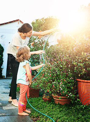 Buy stock photo Water splash, garden or mother and daughter outdoor with plant growth, care and teaching while bonding. Love, family and woman with kid at sunrise for learning, show or gardening on weekend hobby