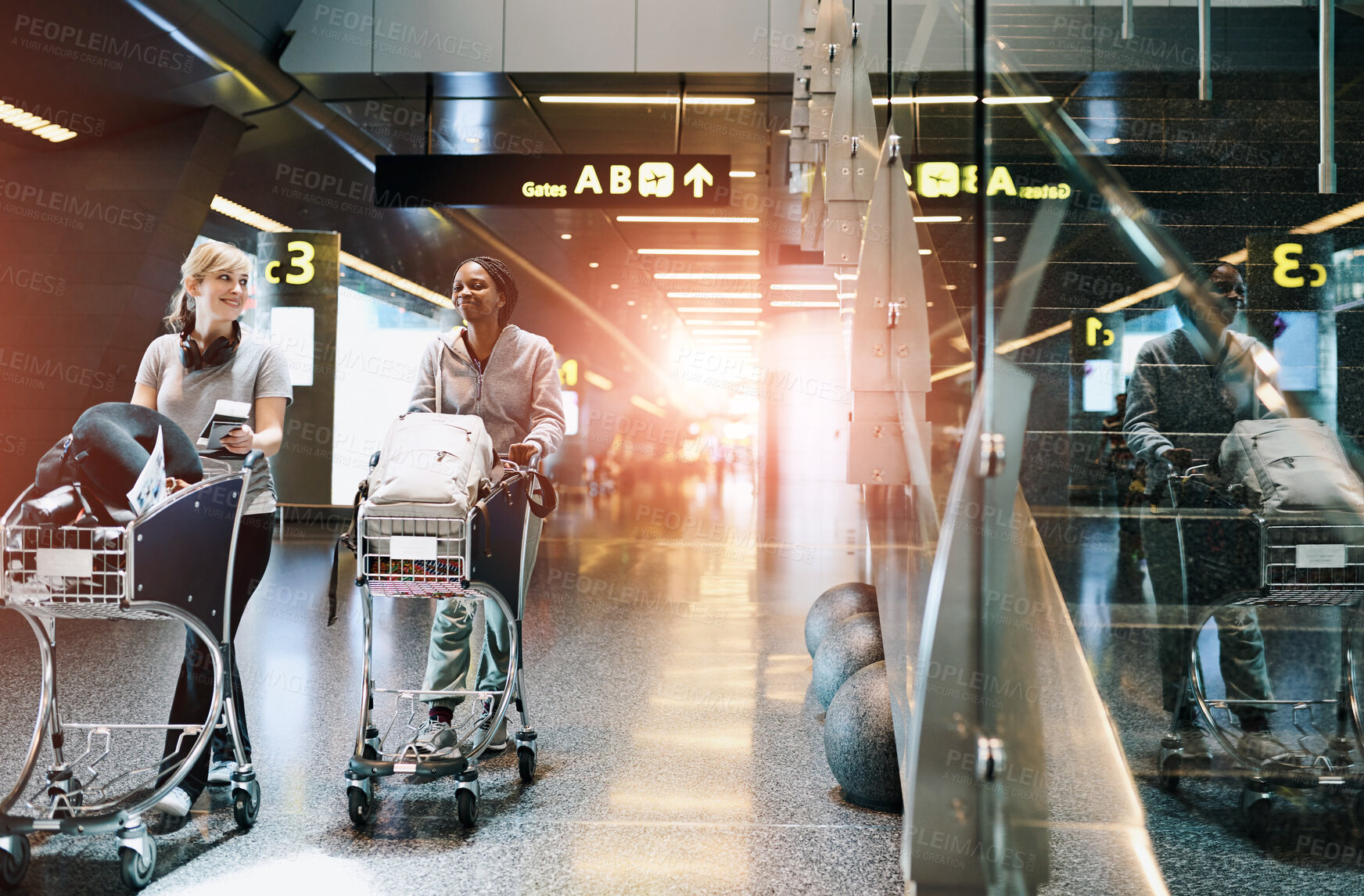 Buy stock photo Travel, friends and women at airport with luggage trolley for vacation, holiday or trip together. Walking, suitcase or happy girls at airline with passport for journey, talk or arrival at flight gate